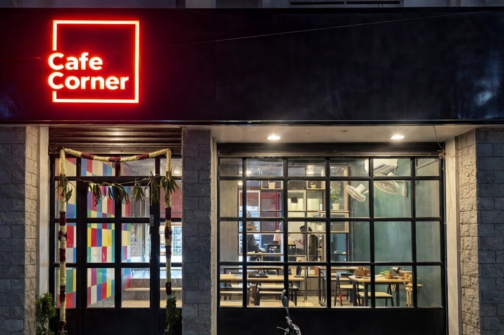 Cafe Corner storefront showing night lights and neon sign